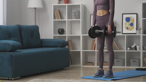 power-training-with-dumbbells-young-woman-is-doing-tilts-in-living-room-fitness-at-home-healthy-lifestyle-and-wellness-caring-about-body-shape